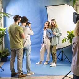 Group of People Standing in Front of a Blue Screen
