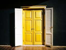 Yellow Door Is Open in a Dark Room