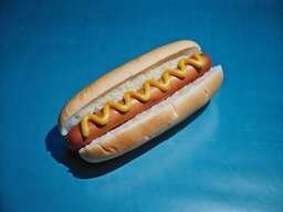 Hot Dog Sitting on Top of a Blue Table
