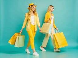 Two Women with Shopping Bags on Blue Background