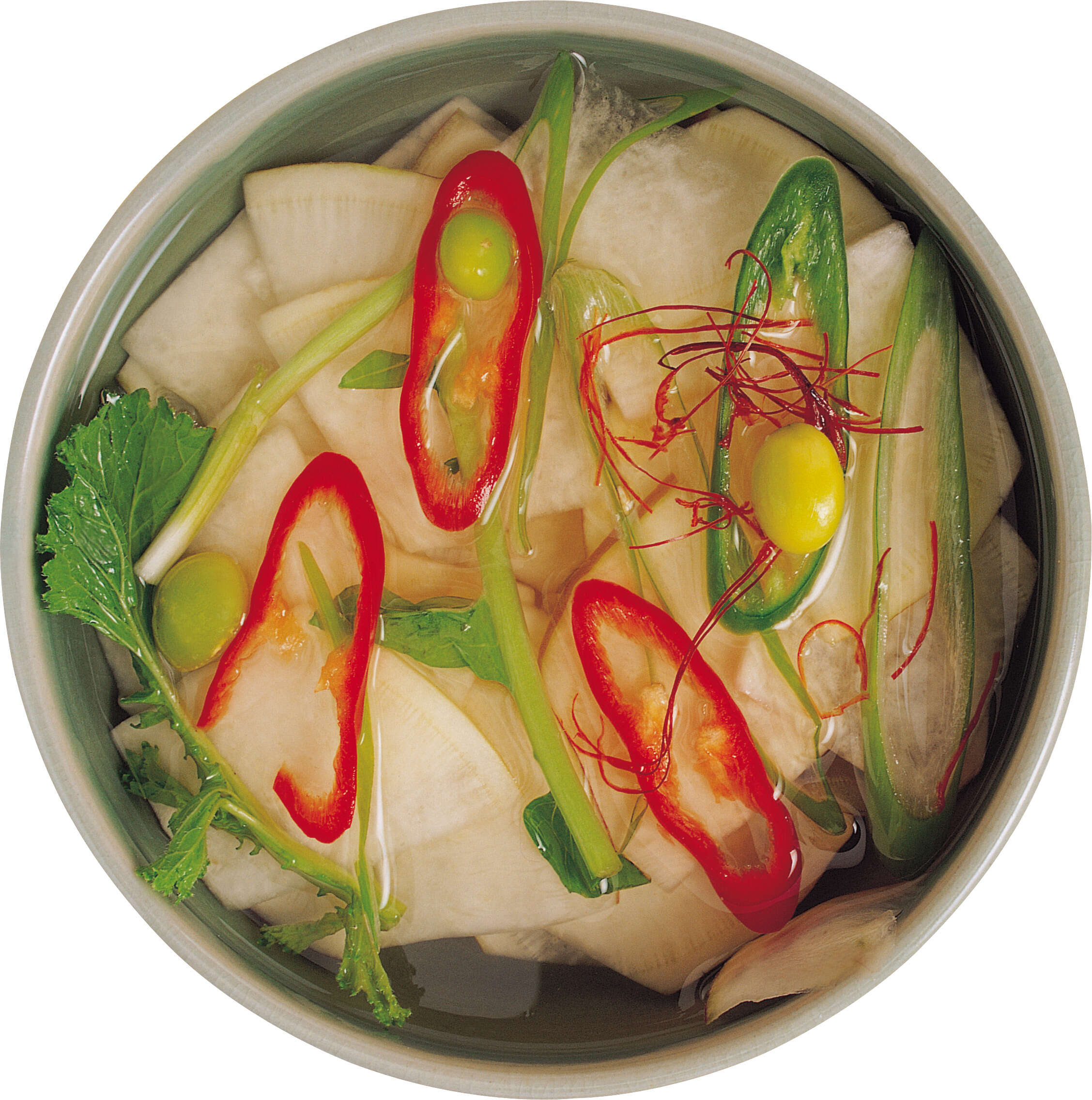 Bowl of food with vegetables in it on a white surface