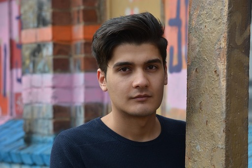 다채로운 벽 앞 에 있는 기둥 에 누워 있는 남성