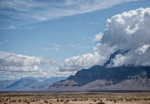 A Desert Landscape With Mountains In The Distance