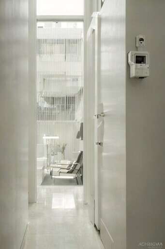 A Hallway With A Chair And A Window