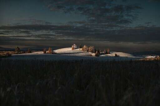 A Snow Covered Field With A House In The Distance