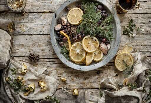 A Bowl Of Food With Lemons Olives And Herbs On A Wooden Table