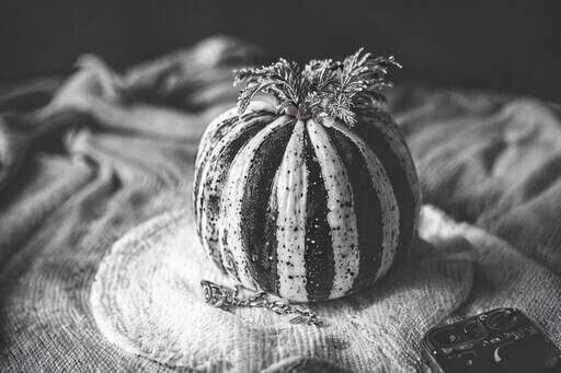 a Black and White Photo of a Small Pumpkin on a Table