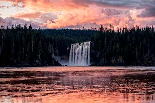 a Large Waterfall in the Middle of a Lake Surrounded by Trees