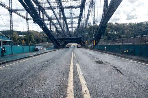 an Image of a Street with a Bridge in the Background