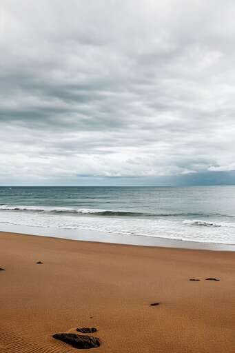 A Beach With Footprints In The Sand