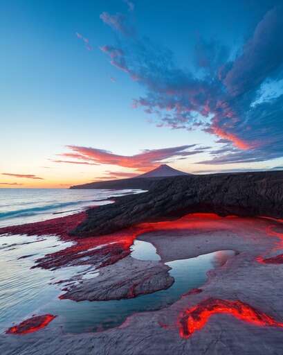 lava covered beach at sunset with volcano in distance 2