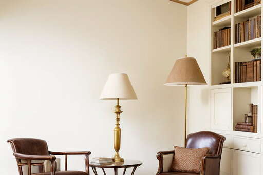 Two Chairs And A Table In A Room With Bookshelves 01