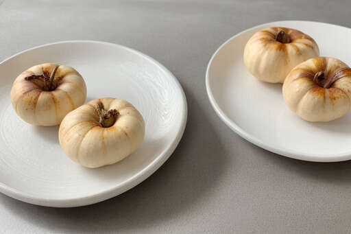 Three Small White Pumpkins On The Plates On The Table